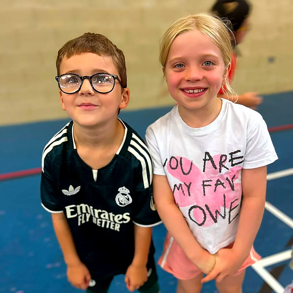 Two children smiling in the sports hall