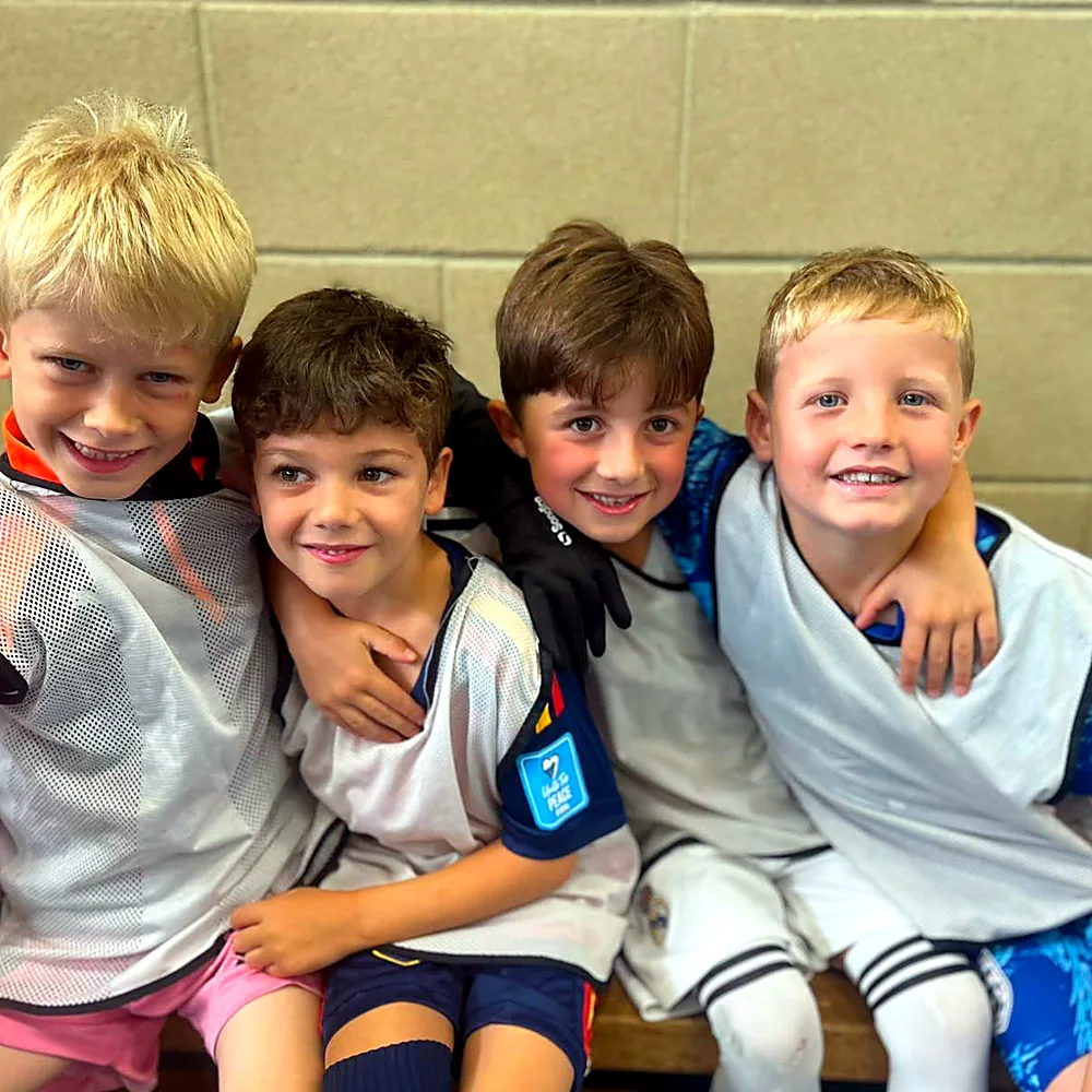 Four young friends sitting together in their bibs
